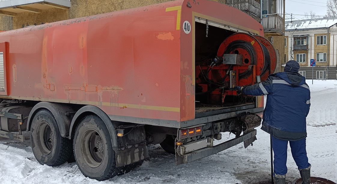 Каналопромывочная машина и работник прочищают засор в канализационной системе в Макарьеве